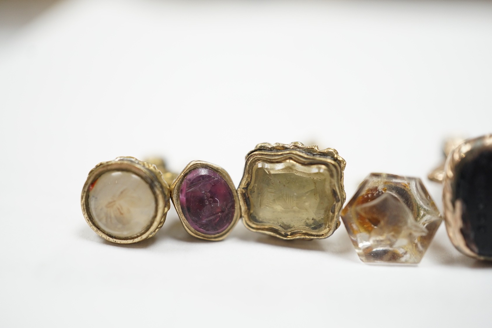 A collection of twelve small 19th century mainly yellow metal fob seals, with assorted matrices including bloodstone, amethyst, citrine and carnelian, largest 22mm.
